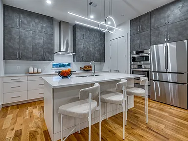 Addison modern kitchen with white island and dark uppers in full renovation