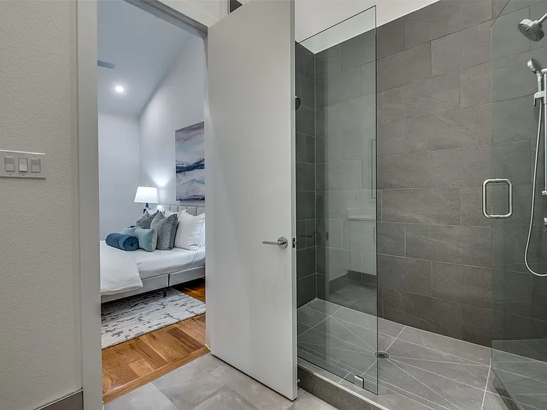 Addison walk-in shower with gray stone tile in full home renovation