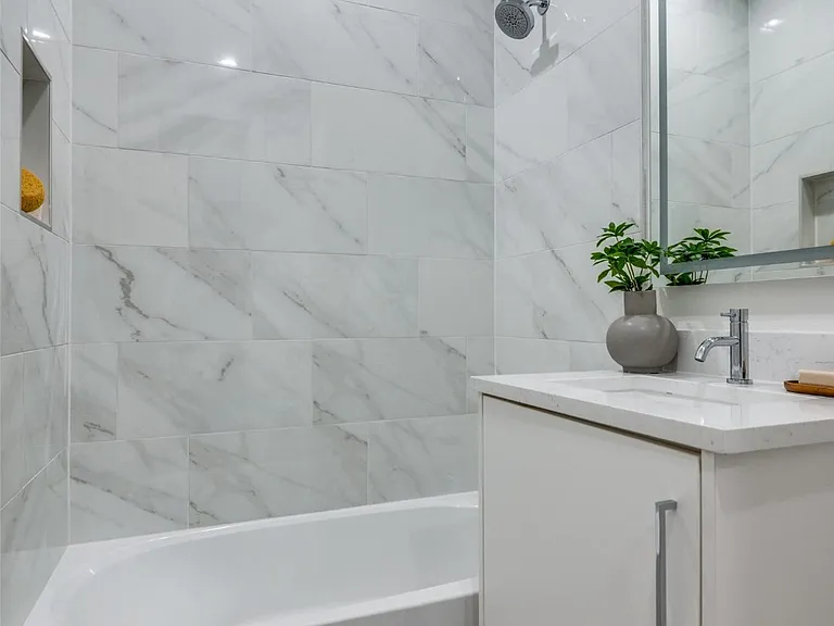 Addison spa-like bathtub alcove with marble tile in gut renovation