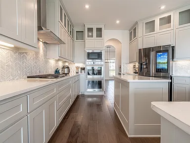 Galley kitchen with chevron backsplash and arched entry in affordable kitchen remodel Allen TX by UHS Remodeling