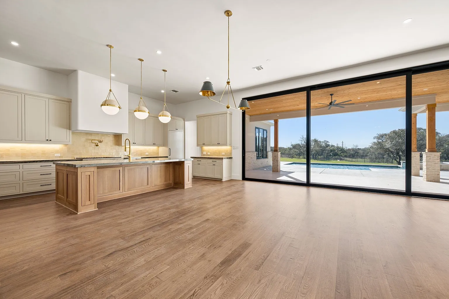 Open concept custom kitchen remodel with pendant lighting and pool view in Allen TX by UHS Remodeling