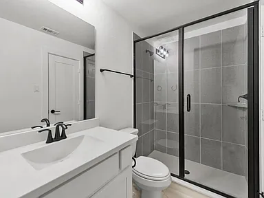 Bathroom remodel in Allen TX with black frame glass shower enclosure by UHS Remodeling