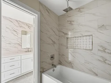 Bathtub shower remodel in Richardson TX with marble niche and glass partition by UHS Remodeling