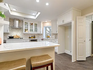 Kitchen remodel in Carrollton TX peninsula bar stools white cabinets by UHS Remodeling