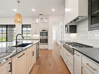 White kitchen with woven pendants and professional range in full home remodel Dallas TX by UHS Remodeling