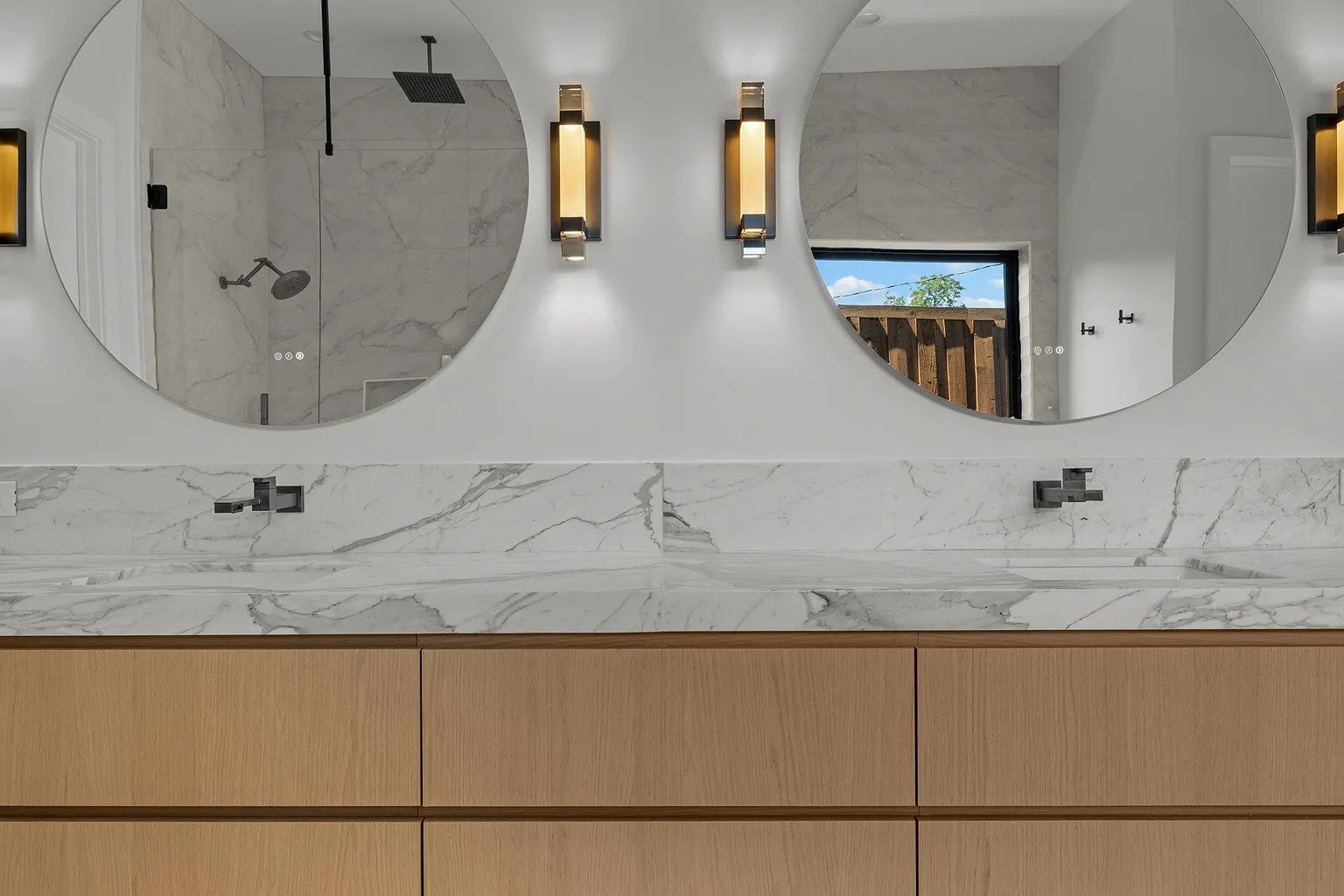 Dual floating vanity with round mirrors in master bathroom remodel Dallas TX by UHS Remodeling