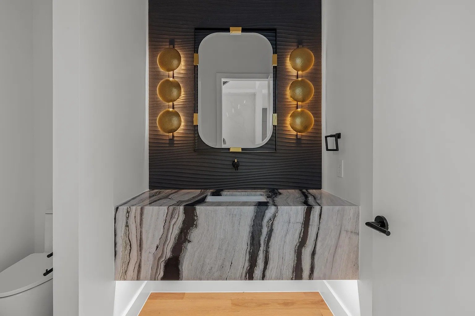 Luxury powder room with onyx slab vanity and orb sconces in full home remodel Dallas TX by UHS Remodeling