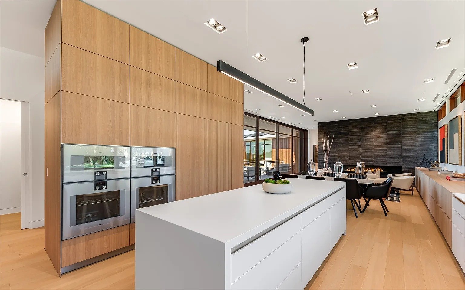 Modern luxury kitchen with walnut cabinets and double wall ovens in Dallas TX by UHS Remodeling
