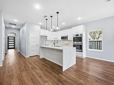 Farmers Branch kitchen from living area with arched doorway in full renovation