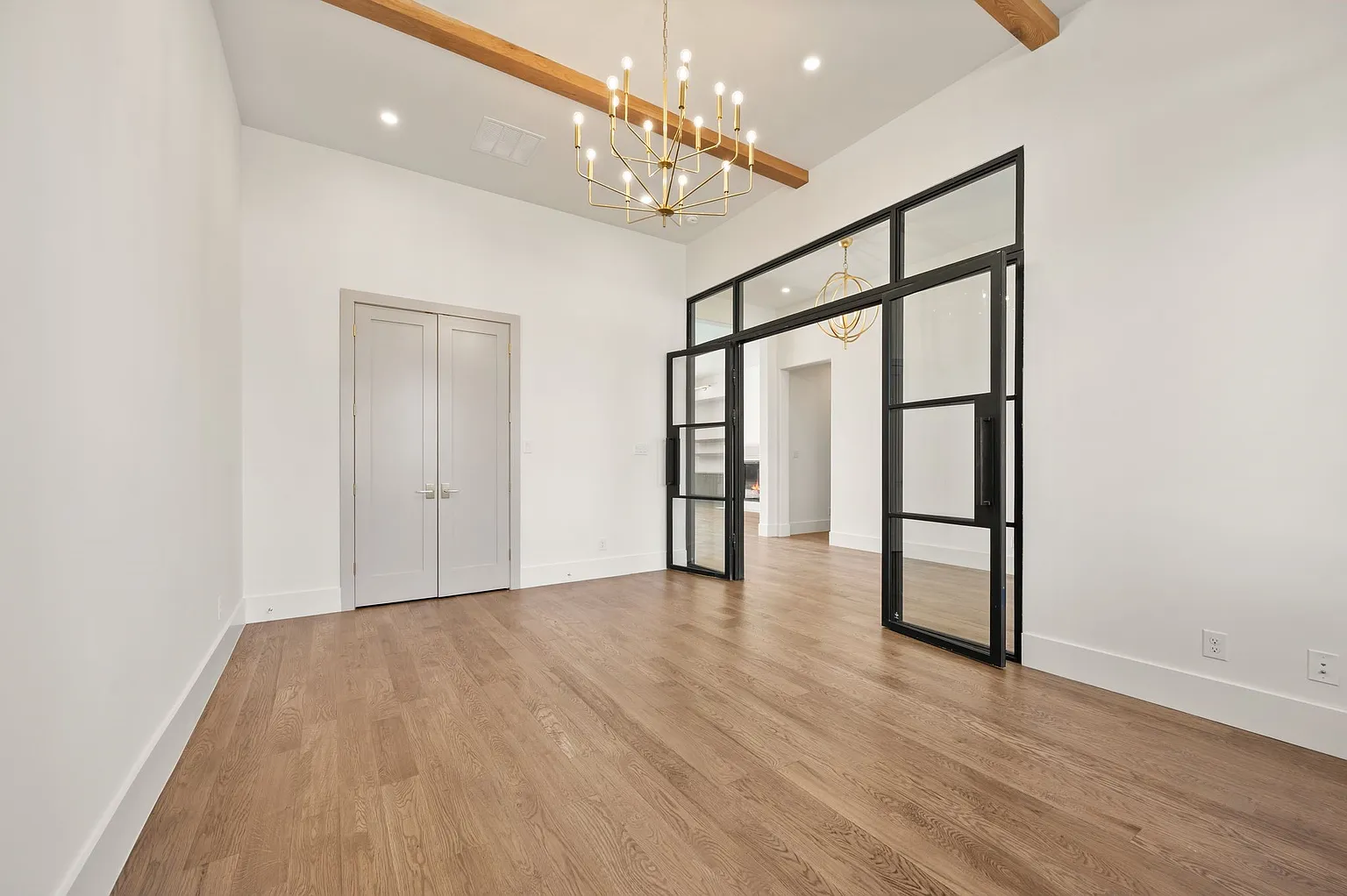 Home office with steel and glass French doors and exposed beam in full home renovation Frisco TX by UHS Remodeling