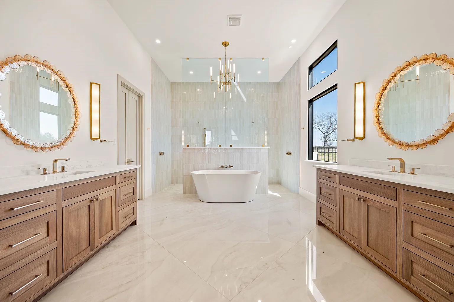 Luxury primary bathroom with freestanding tub and dual round vanities in full home renovation Frisco TX by UHS Remodeling