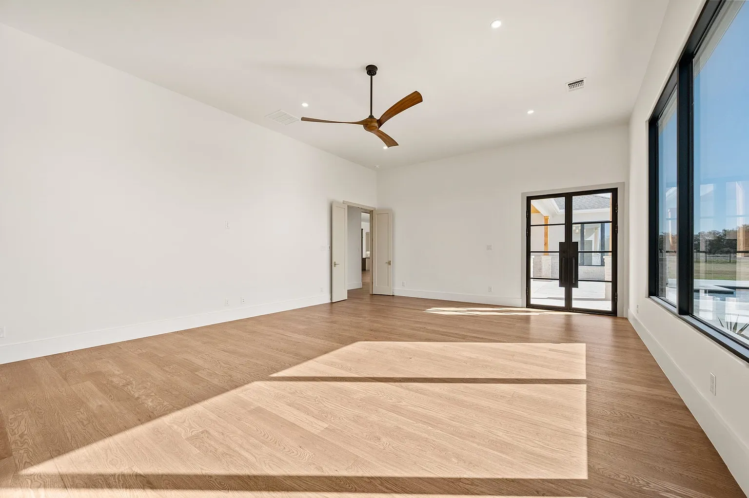Primary bedroom with soaring ceilings and wall of windows in full home renovation Frisco TX by UHS Remodeling