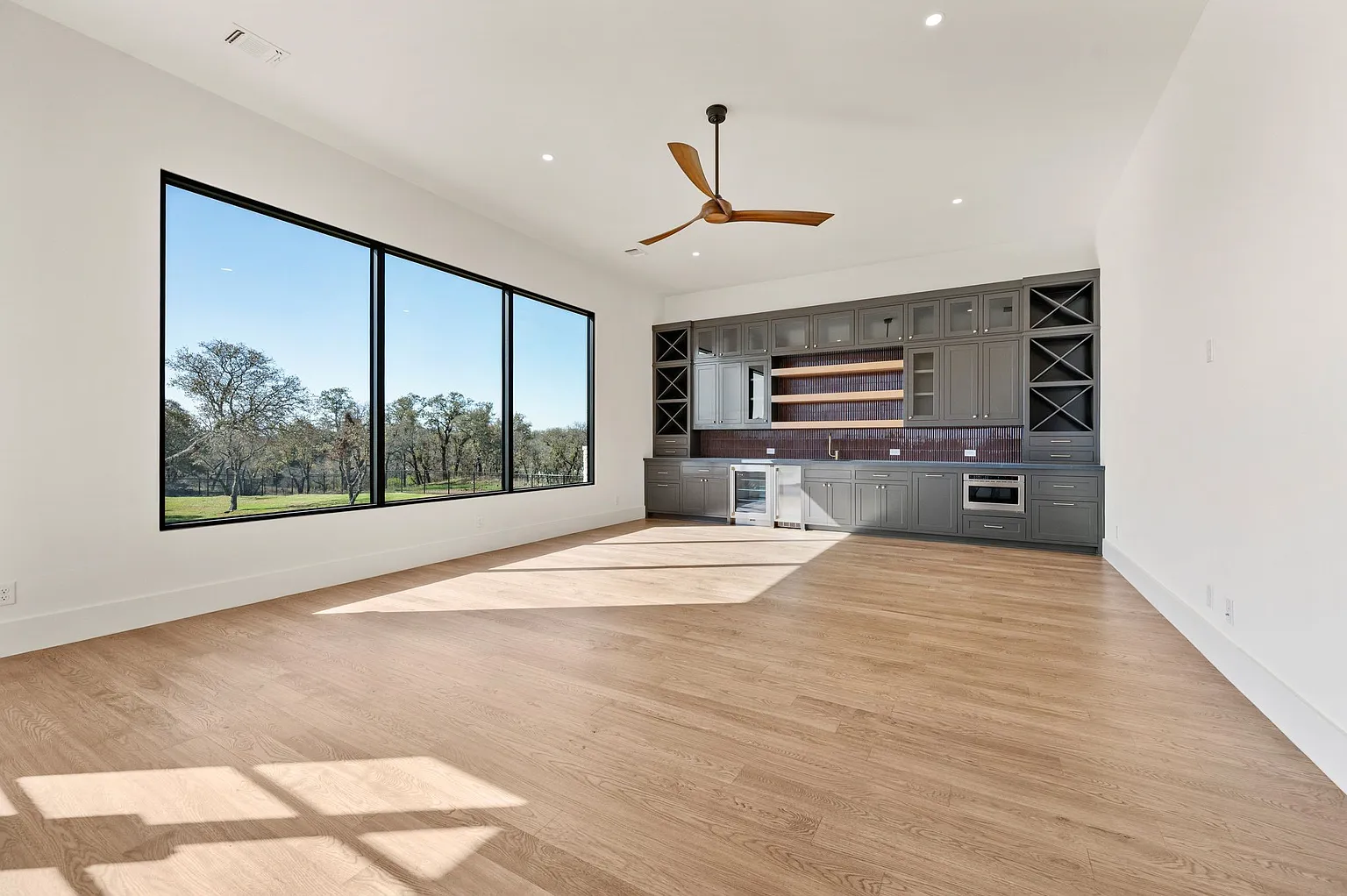 Wet bar lounge with wine storage and panoramic window view in full home renovation Frisco TX by UHS Remodeling