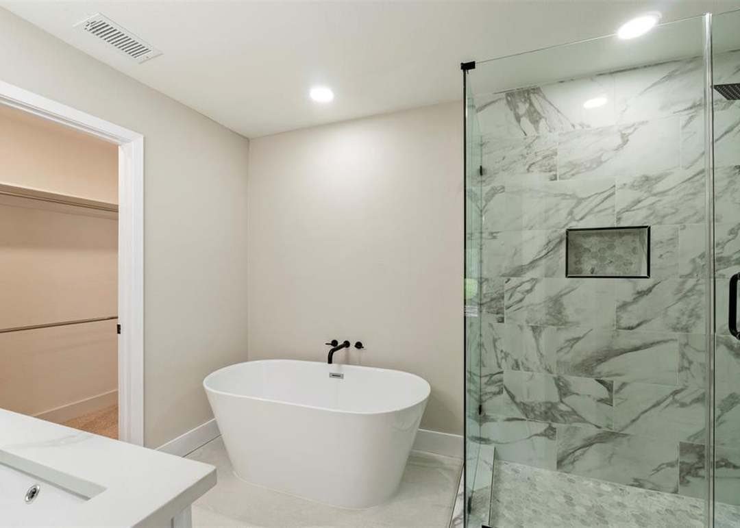 Dallas TX primary bath with freestanding tub and marble walls
