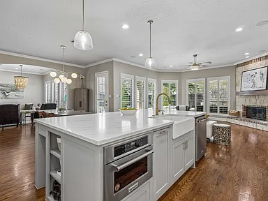 Kitchen island with wine rack and globe pendants in Garland TX home by UHS Remodeling