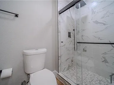 Small bathroom remodel in Garland TX with marble tile shower and hex floor by UHS Remodeling