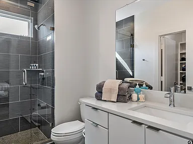 Bathroom remodel dark tile shower white vanity Highland Park TX