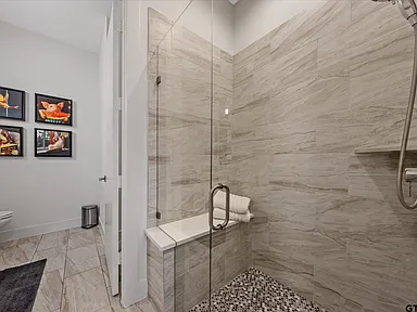 Walk-in shower with marble tile and built-in bench Highland Park TX