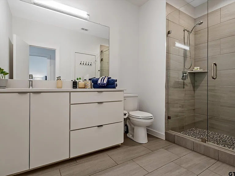 Walk-in shower with glass enclosure and pebble floor in Highland Park TX bathroom remodel