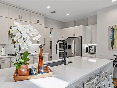Kitchen island with quartz countertop and orchid centerpiece in Highland Park TX home