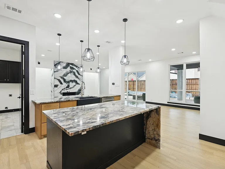 Modern kitchen with marble waterfall island by UHS Remodeling