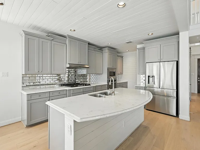 Farmhouse-transitional kitchen remodel in Little Elm TX with gray shaker cabinets mirrored backsplash and shiplap ceiling by UHS Remodeling