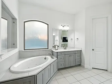 Master bathroom remodel in Little Elm TX with corner tub arched window and gray vanity by UHS Remodeling