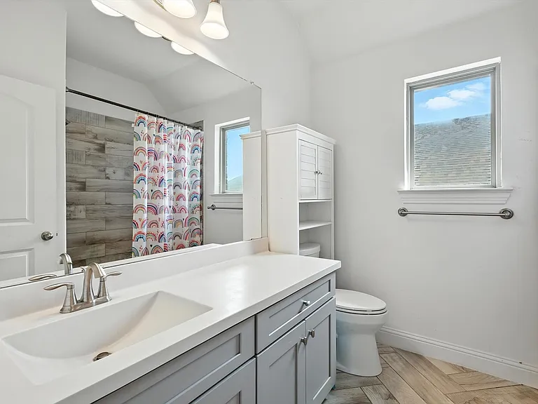 Secondary bathroom remodel in Little Elm TX with gray vanity and herringbone floor