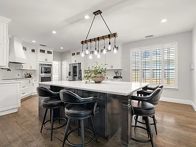 Kitchen island with bar seating and plantation shutters in Plano TX home remodel