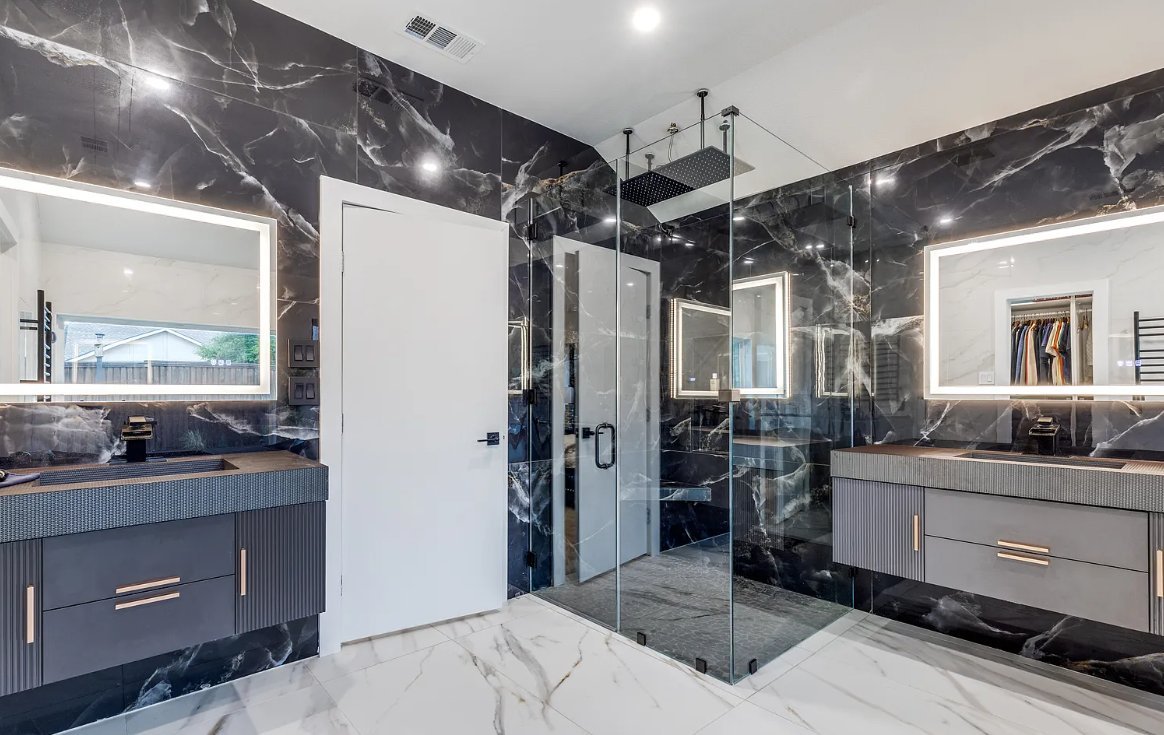 Master bathroom dual vanity with black marble and LED mirrors in luxury bathroom remodel Plano TX by UHS Remodeling