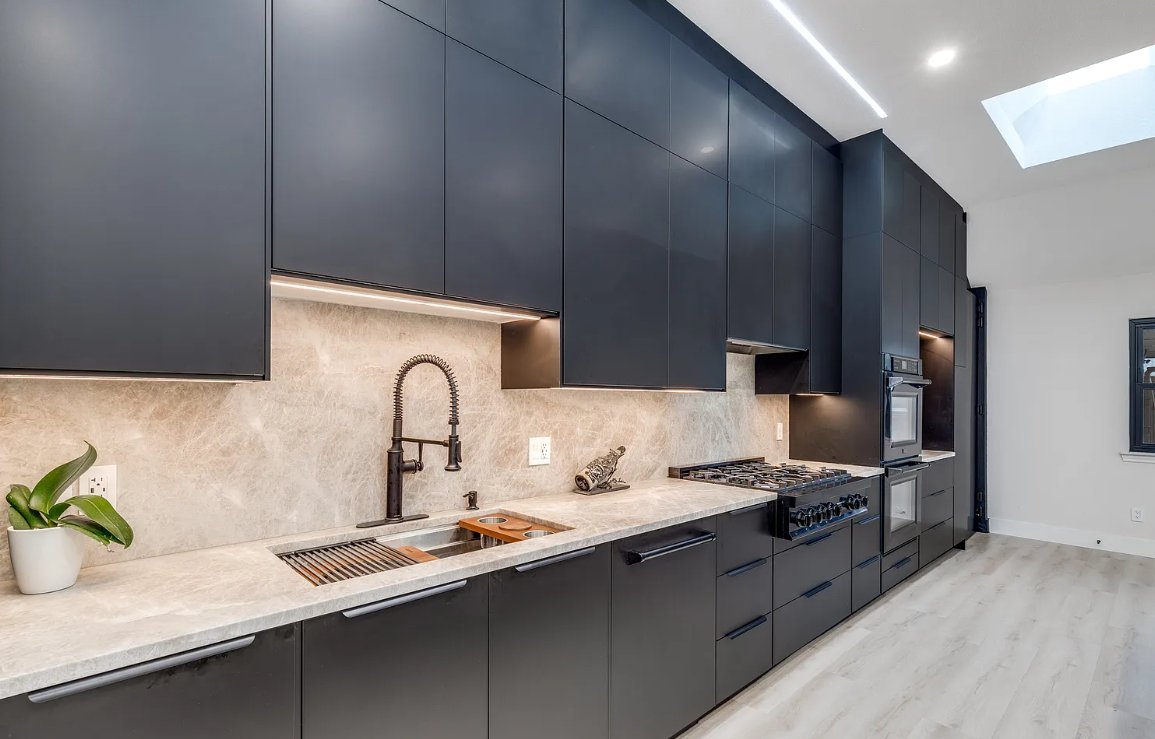 Black cabinet wall with pro range and commercial faucet in modern kitchen remodel Plano TX by UHS Remodeling