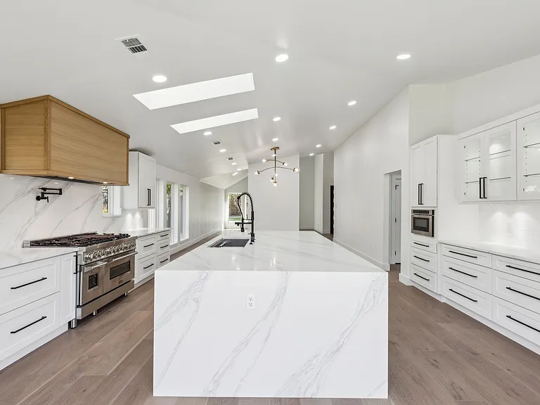 Expanded open kitchen with pro gas range and waterfall island in full home renovation Richardson TX by UHS Remodeling