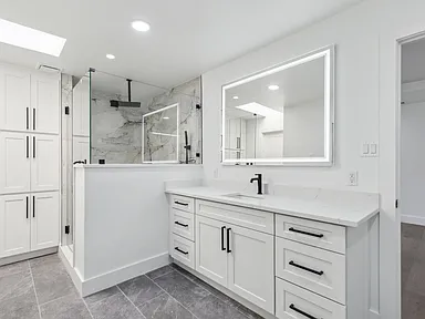 Guest bathroom with marble walk-in shower and LED mirror in full home renovation Richardson TX by UHS Remodeling
