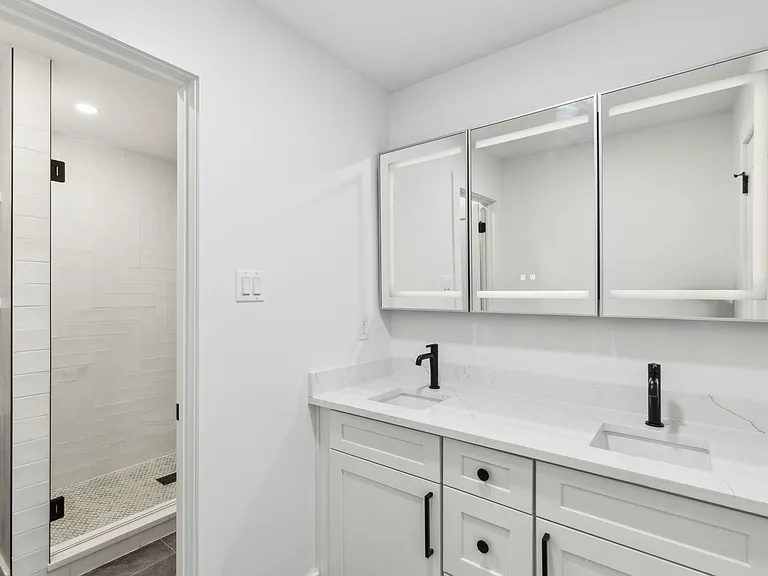 Modern master bathroom with dual vanity and walk-in shower in 1970s home renovation Richardson TX by UHS Remodeling
