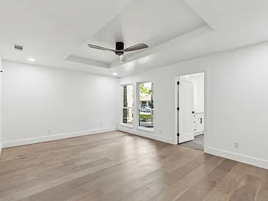 Primary bedroom with tray ceiling and ensuite entry in 1970s home renovation Richardson TX by UHS Remodeling