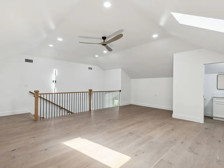 Vaulted upstairs loft bonus room with skylight in full home renovation Richardson TX by UHS Remodeling