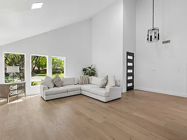 Vaulted great room with sectional and natural light after 1970s home renovation Richardson TX by UHS Remodeling