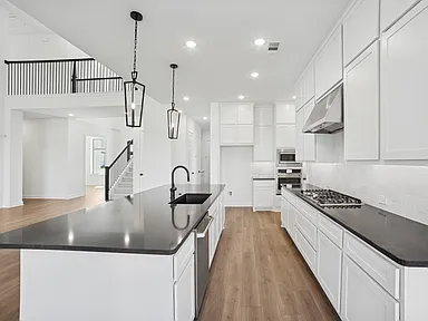 Kitchen side view with black counters and matte black sink in Rockwall TX by UHS Remodeling