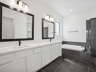 Master bathroom remodel in Rockwall TX with double vanity black mirrors and freestanding tub by UHS Remodeling
