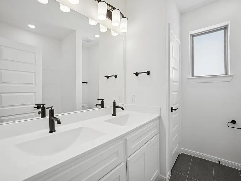 Secondary bathroom with white double vanity and matte black faucets in Rockwall TX