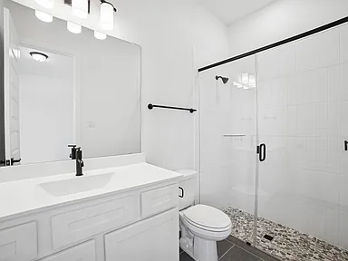 Walk-in shower with subway tile and pebble floor in Rockwall TX bathroom