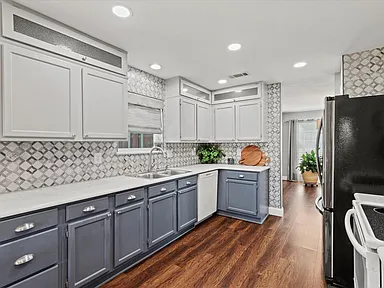 Two-tone kitchen remodel in Rowlett TX with white upper cabinets dark lower cabinets and diamond backsplash by UHS Remodeling