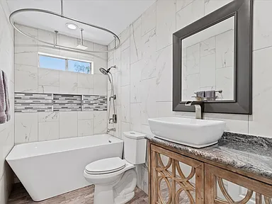 Guest bathroom with marble tile and rustic wood vanity in Rowlett TX