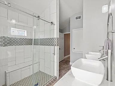 Walk-in shower with blue and white geometric tile in Rowlett TX bathroom