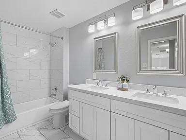 Hall bathroom white double vanity marble tub surround Sachse TX UHS Remodeling