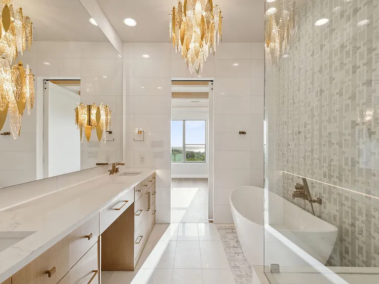 Luxury master bathroom remodel in The Colony TX with floating vanity gold chandelier and freestanding tub by UHS Remodeling