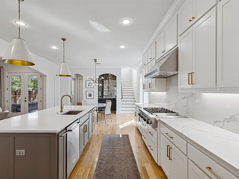 Luxury kitchen remodel in University Park TX with gold faucet gas cooktop and arched doorway by UHS Remodeling