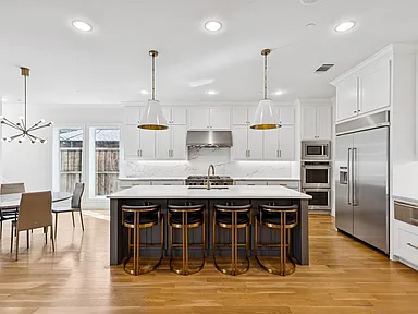 Kitchen remodel in University Park TX with dark island gold stools and white shaker cabinets by UHS Remodeling
