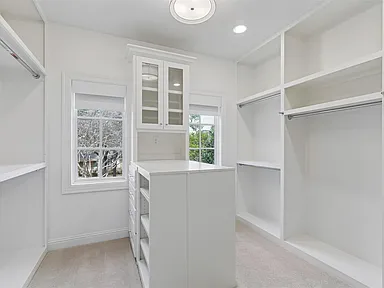 Walk-in closet with white built-ins and center island in University Park TX home