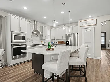 Large kitchen remodel in Wylie TX with white shaker cabinets dark island and herringbone backsplash by UHS Remodeling
